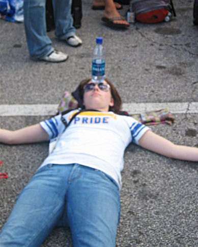 I wish I could say I staged this photo because it is too perfect for this topic- my shirt even says pride on it. This was in 2008 in Florida. When waiting for a bus I laid down in the parking lot with a water bottle on my head for my headache. I looked ridiculous, but I needed to do it.